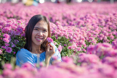 Portrait of smiling young woman with pink flowers