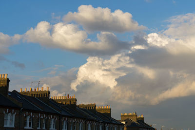 Low angle view of buildings against cloudy sky