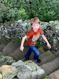 Cute boy sitting on rock