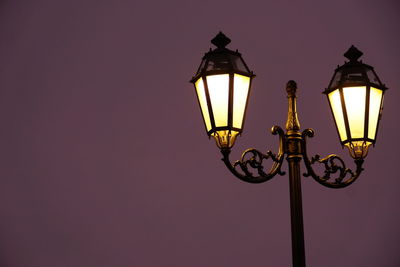 Low angle view of illuminated street light during dusk