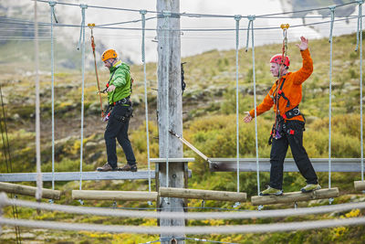 Two men balancing on high rope obstacle course in iceland