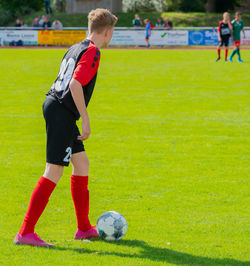 Children playing soccer on field