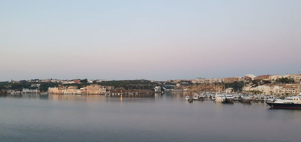 Scenic view of river by buildings against clear sky