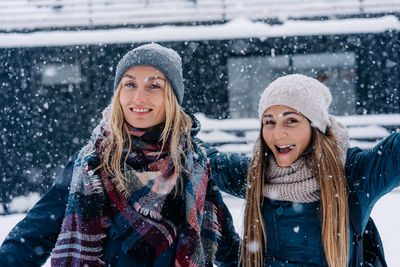 Cool happy diverse thirties women having fun as kids in snowfall