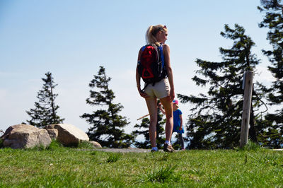 Full length of woman standing on field against sky