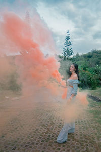 Woman with distress flare standing on footpath