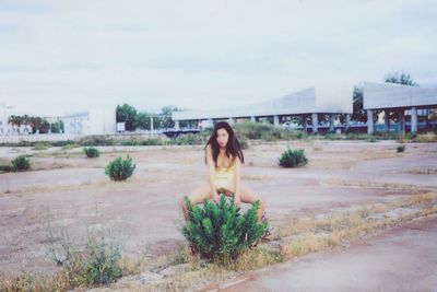 Portrait of young woman against plants