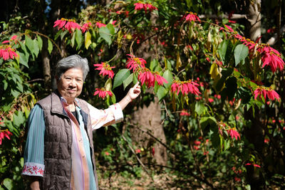 Portrait of smiling senior woman standing in park