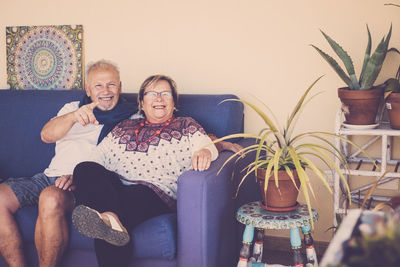 Portrait of smiling couple sitting at home