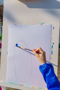 Artist's work place. a kid paints with blue gouache a picture. open air workshop