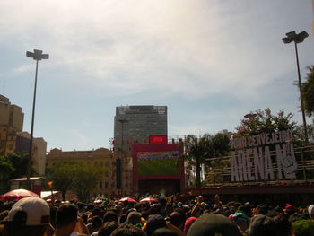 People on street in city against sky