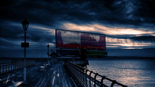 View of pier on sea against cloudy sky