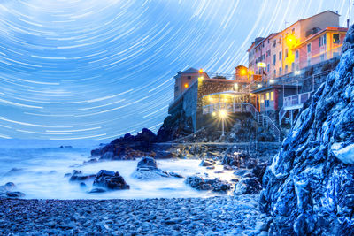 Scenic view of illuminated sea against sky at night