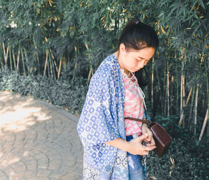 Full length of woman standing by plants