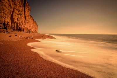 Scenic view of beach against sky during sunset