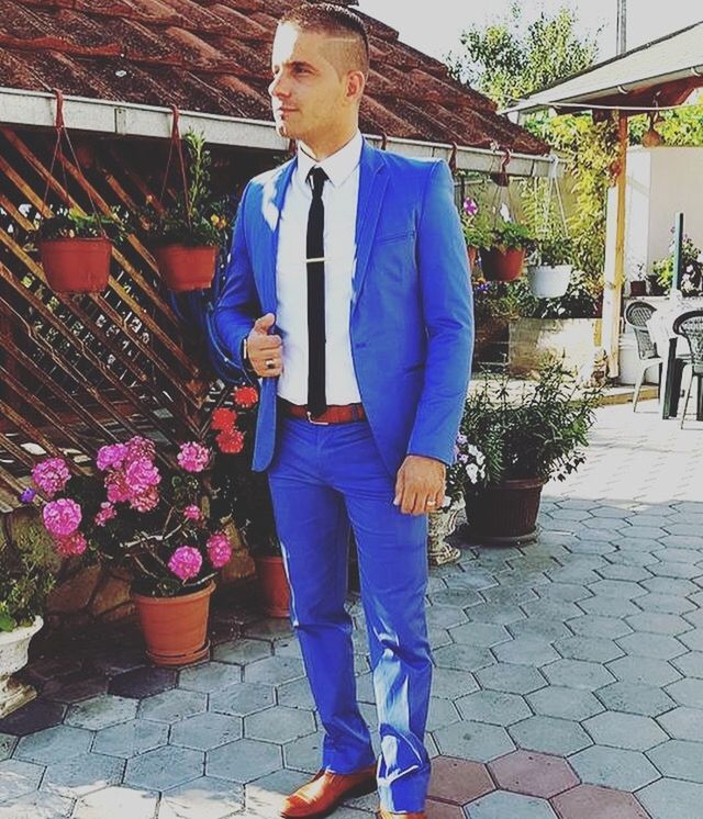 FULL LENGTH OF MAN STANDING BY POTTED PLANTS