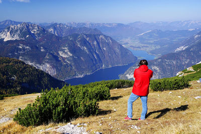 Rear view of man standing on mountain against valley