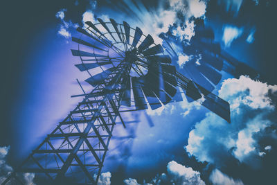 Low angle view of ferris wheel against blue sky