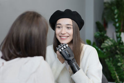 A european woman with a bionic prosthesis on her arm is talking to friends in a public place