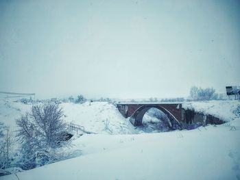Arch bridge over snow against sky during winter