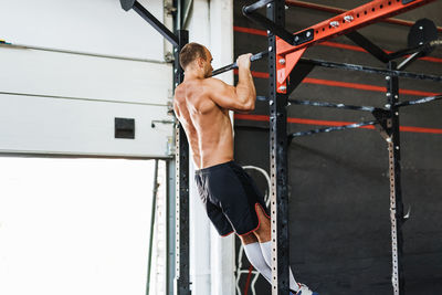 Shirtless muscular man exercising in gym