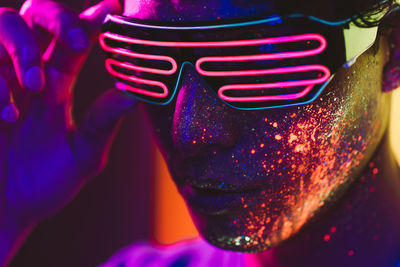 Close-up of man with multi colored face paint wearing eyewear