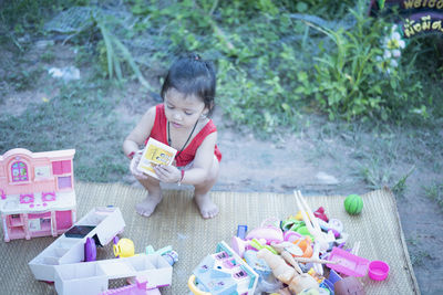 High angle view of boy playing with toys on field