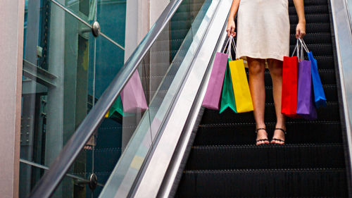 Low section of woman on multi colored umbrella