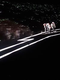 People on street in city against sky at night