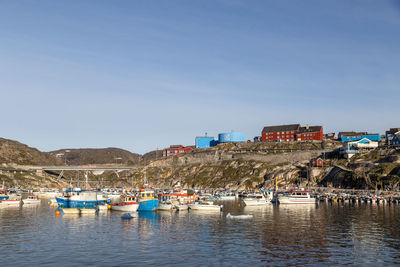 Boats moored in lake against clear sky