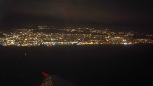 Illuminated cityscape against sky at night