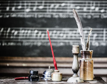 Old-fashioned writing equipment with candlestick holder on table