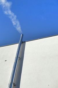 Low angle view of vapor trail against clear blue sky