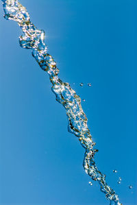Single jet of water sky blue background