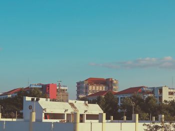 Buildings in city against blue sky