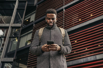 Low angle view of man using mobile phone