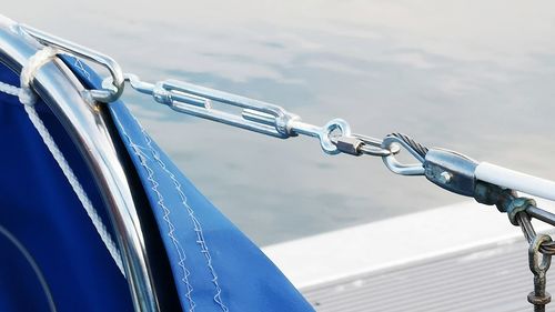 Close-up of bicycle on railing against blue sky