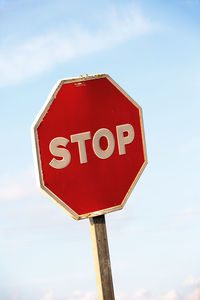 Low angle view of road sign against sky