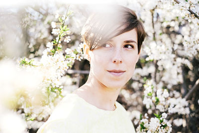 Young woman among blossoming trees