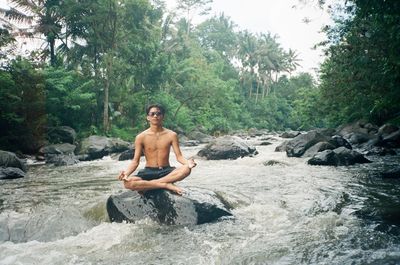 Full length of man sitting on rock