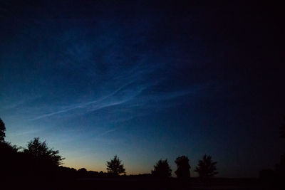 Low angle view of silhouette trees against sky