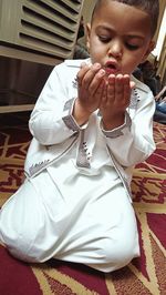 Low angle view of girl sitting on carpet at home