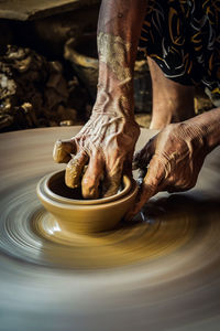 Cropped hands of worker making pot