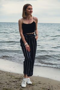 Rear view of woman standing at beach