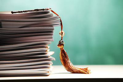 Stack of books with key at classroom against blackboard