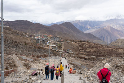 Rear view of people walking on mountain