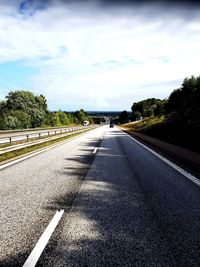 Road leading towards city against sky