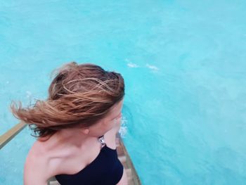 High angle view of woman standing by swimming pool