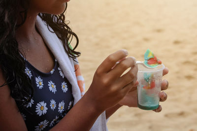 Midsection of woman holding bottle