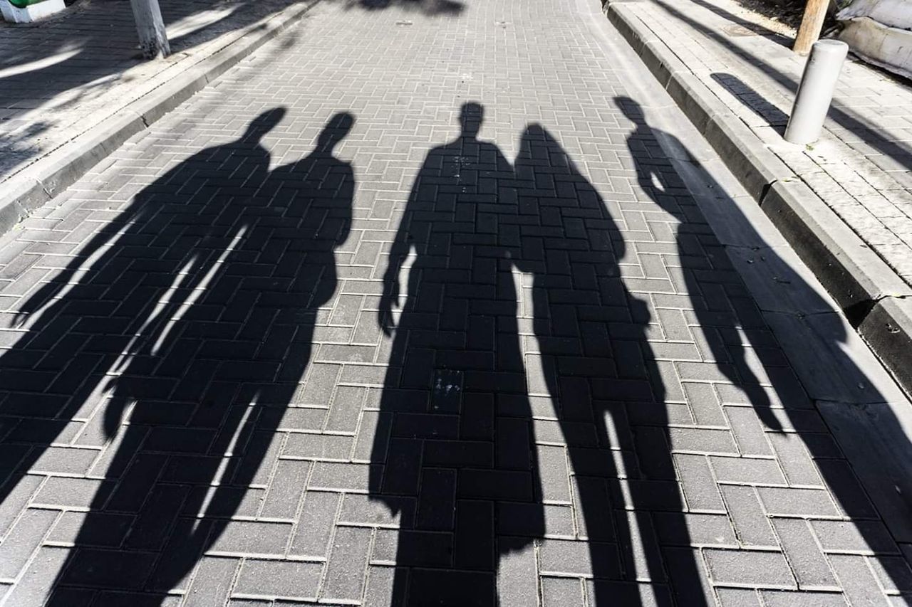 shadow, sunlight, high angle view, group of people, men, day, real people, nature, focus on shadow, architecture, city, people, togetherness, outdoors, adult, group, medium group of people, street, sunny, unrecognizable person, paving stone